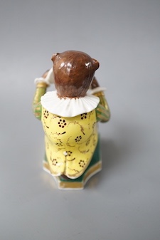 A Derby rare figure from a bear band, c.1820, wearing a green, gold and yellow jacket playing the cymbals, seated on the base, crossed swords mark in blue 10cm